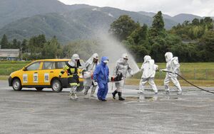 佐渡空港の消火救難訓練で、負傷者を搬送する参加者=10月23日、佐渡市秋津
