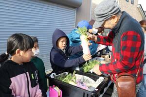 一の日市で丹精込めて育てた野菜などを販売する上下浜小の児童＝上越市柿崎区