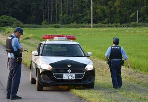 　男児が行方不明になった石川県立小松特別支援学校の周辺を捜索する警察官＝３０日午後、小松市