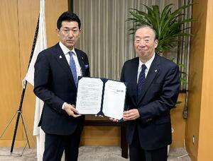 「病院船」への医療人材の派遣に関する協定締結式に出席した赤間防災相(左)=22日、東京都千代田区