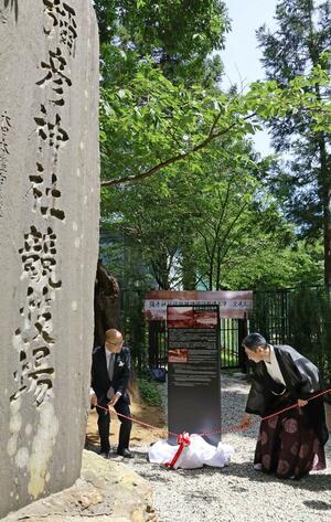 弥彦神社競技場の記念碑のそばに設置した解説ボードの除幕式=弥彦村弥彦