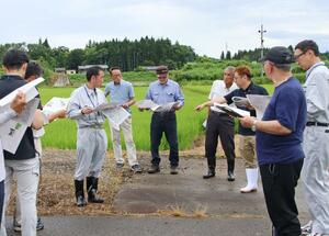 刈谷田川沿いの遊水地で現地確認をする地元の区長ら=見附市
