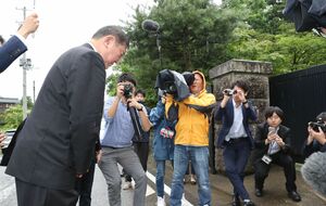 田中家を訪れた自民党の石破茂氏(左)。門の前で一礼する=2018年7月、柏崎市の田中家