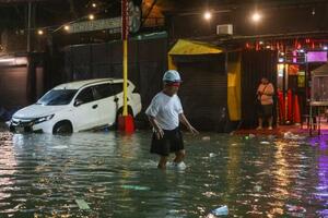 　台風が直撃し浸水した道路を歩く男性＝９日、マニラ首都圏（ゲッティ＝共同）