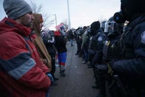 　治安当局の職員らと向かい合うデモ隊＝１７日、米ミネソタ州ミネアポリス（ロイター＝共同）