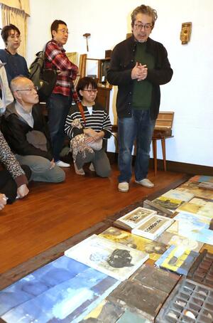 鑑賞会で作品について解説する長沢明さん(右)=新発田市大手町2