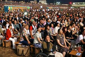 観覧席で花火を眺める観客＝2025年8月2日、長岡市の信濃川右岸