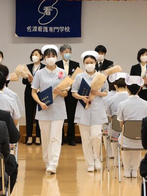 教職員や在校生に見送られながら、卒業式の会場から退場する卒業生=佐渡市千種