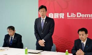 自民党本部で開かれた選対打ち合わせ会であいさつする西村選対委員長(中央)=8日午後、東京・永田町