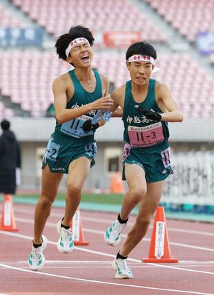 男子　中越の２区波形泰良（左）が３区丸山展につなぐ＝ビッグスワン