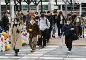 今シーズン一番の冷え込みとなり、冬の装いで通勤、通学する人たち=11月19日、新潟市中央区
