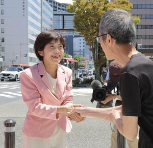 再選を果たし、街頭で市民と握手する打越さく良さん=21日、新潟市中央区
