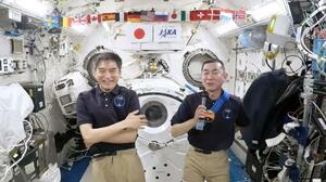国際宇宙ステーションから記者会見する大西卓哉飛行士(左)と油井亀美也飛行士=4日(JAXAの中継より)