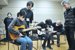 「大人向け初めてのバンド体験会」で初めての楽器に触れる参加者=12月22日、魚沼市干溝