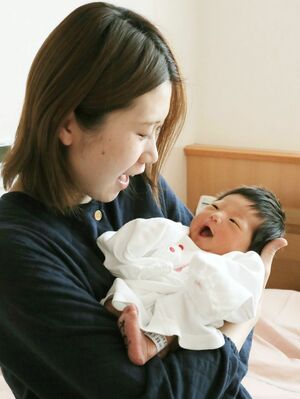 生後4日の長女を抱く岡田綾子さん。小さな手足を動かし、さまざまな表情を見せる長女にいとしさが募る=三条市