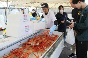 特売のカニを買い求める来場者＝７日、佐渡市赤泊