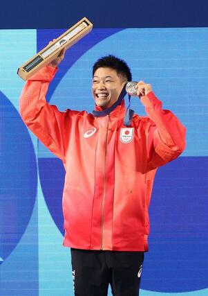 男子高飛び込み決勝　表彰式でメダルを掲げる玉井陸斗＝８月１０日、パリ郊外（新潟日報社写真映像部・新井田悠）