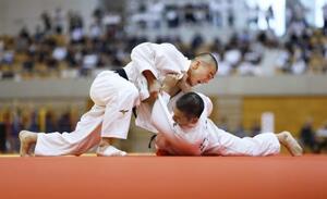 男子66キロ級決勝で、足立学園・嶋貫蓮(右)を攻める佐賀商・田中龍希=ジップアリーナ岡山