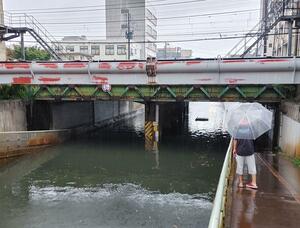 激しい雨で冠水したアンダーパス。水没したとみられる車の屋根部分が見える=8月25日午後5時前、長岡市城内町3