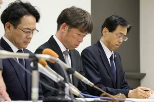 沈痛な表情で会見に臨む寺尾宏治ソフトテニス部顧問（中央）＝５月１０日、新潟市中央区