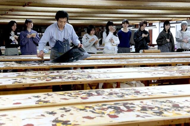 染色の工程を見学する学生＝２２日、十日町市明石町の青柳