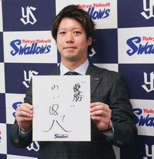 　契約更改交渉を終え、記者会見で来季の抱負を記した色紙を掲げるヤクルト・山田＝２８日、神宮球場