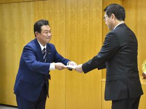 白山エリアのスポーツ施設整備について、中原八一市長（右）に要望書を手渡した荒井宏幸市議＝新潟市役所