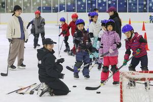元五輪選手の大澤ちほさんからアイスホッケーの指導を受ける子どもたち=3月30日、新潟市中央区鐘木