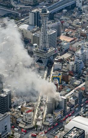 大阪市浪速区の火災現場。奥は通天閣=9日午前11時17分(共同通信社ヘリから)