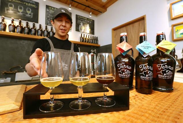 クラフトビール醸造所「ＴＥＲＲＡ」が提供する３種類のビールと醸造責任者の横井穂高さん＝上越市寺町３
