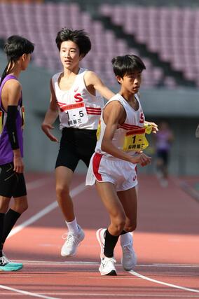 県中学駅伝男子決勝 3位入賞の柏崎・第三 5区大瀧光(左)がアンカーの市川太陽(右)にタスキをつなぐ=11月8日、デンカビッグスワン