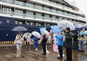 雨の中、市民の歓迎を受ける国際クルーズ船「ル・ジャック・カルティエ」の乗客＝佐渡市の小木港