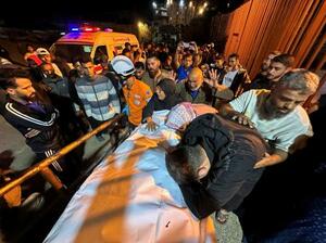 　２８日、パレスチナ自治区ガザ南部ハンユニスの病院で、イスラム組織ハマスの空爆で死亡した人のそばに集まる人々（ロイター＝共同）