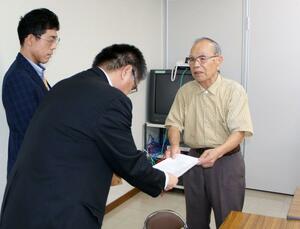 佐渡市幹部に要請書を手渡す市民グループのメンバー(右)=7月16日、同市千種
