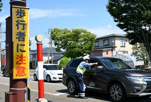 事故が多い交差点で注意喚起する糸魚川署員=糸魚川市東寺町1
