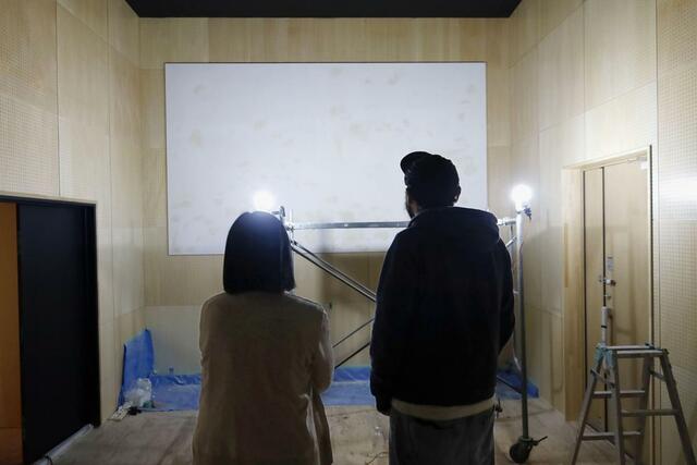 スクリーンを見つめる斉藤裕樹さん（右）と富士子さん夫妻＝北海道東川町