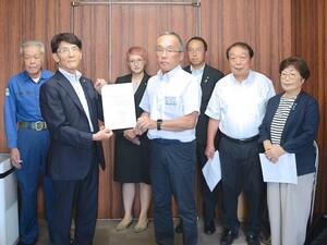 イントランス選定に反対する意向表明書を根津和博副町長(中央)に手渡す町議6人=22日、津南町役場