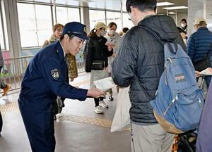 　ＪＲ都賀駅で情報提供を求めるチラシを配る千葉県警の捜査員＝１３日午前、千葉市