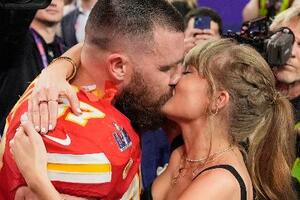 昨年2月、スーパーボウルの試合を終えたチーフスのトラビス・ケルシー選手(左)とキスするテイラー・スウィフトさん=米ラスベガス(AP=共同)
