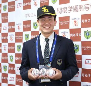 ドラフト指名あいさつで、ソフトバンクの王貞治会長のサインボールなどを受け取った池田栞太さん＝２０２５年１０月、上越市の関根学園高