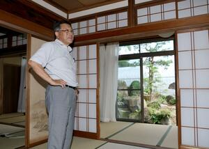 今夏オープンした農家民宿「水草たなか」と、運営する櫛池農業振興会の惣塚泰次会長=上越市清里区