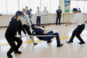 不審者役の海保職員をさすまたで取り押さえる佐渡汽船職員=佐渡市両津湊