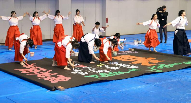 大きな筆を使ったパフォーマンスを披露する東京学館新潟高校の書道部員＝４日、新潟市中央区