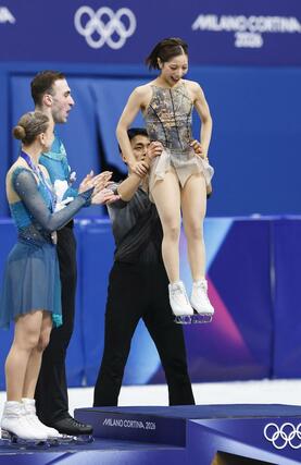 金メダルの表彰台に三浦璃来を乗せる木原龍一（奥）＝ミラノ（共同）