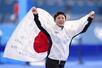 ミラノ・コルティナ冬季五輪のスピードスケート女子500メートルで銅メダルを獲得し、日の丸を掲げる高木美帆さん=2月(共同)