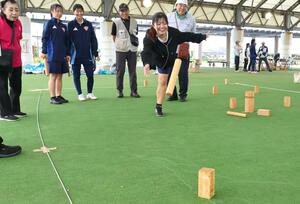 柏崎市で開かれたコート上のまきを倒すスポーツ「クッブ」の大会=柏崎市西港町