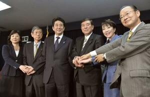 2012年12月、自民党の新執行部が発足し、記者会見で手を重ねる安倍総裁(左から3人目)、高市政調会長(同5人目)ら=東京・永田町の党本部