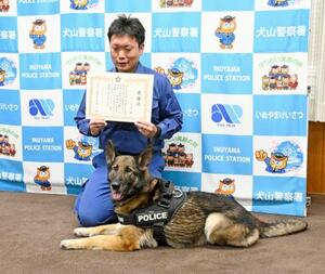 　住居侵入の容疑者逮捕に貢献し、表彰された警察犬リンダ号と山口智章巡査部長＝１９日午前、愛知県警犬山署