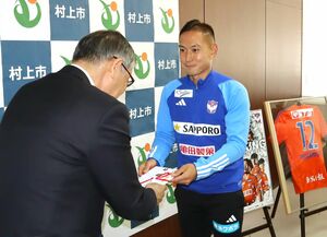 義援金の目録を手渡すアルビレックス新潟の早川史哉選手=村上市役所
