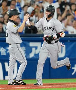 11回、勝ち越しソロを放ち、コーチとタッチを交わす巨人・坂本(右)=横浜